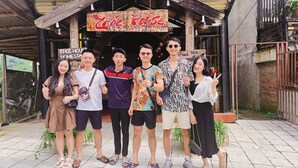 A group of people posing in front of a wooden building with a sign that reads "Zoo Horse." - Thóc house (Ta Van)