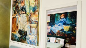 A room with a bed, a blue sofa, and two paintings on the wall. - BluMare ArtHouse (Salerno)