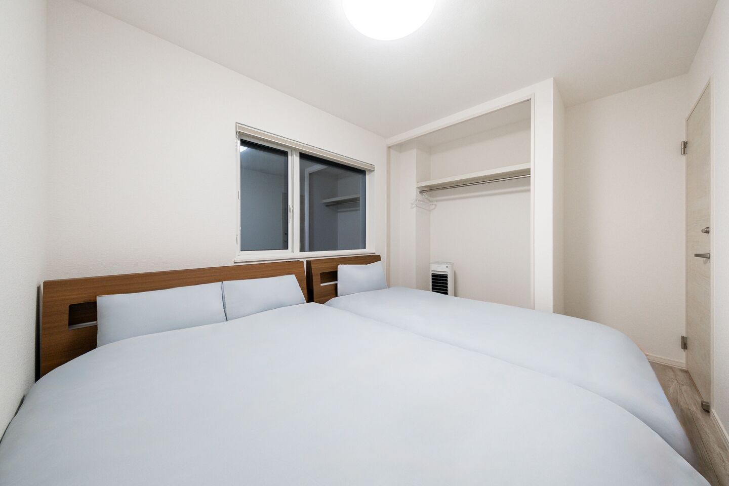 A neatly made bed with white linens in a hotel room.
