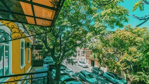 Vista de una calle con coches aparcados, árboles y edificios.