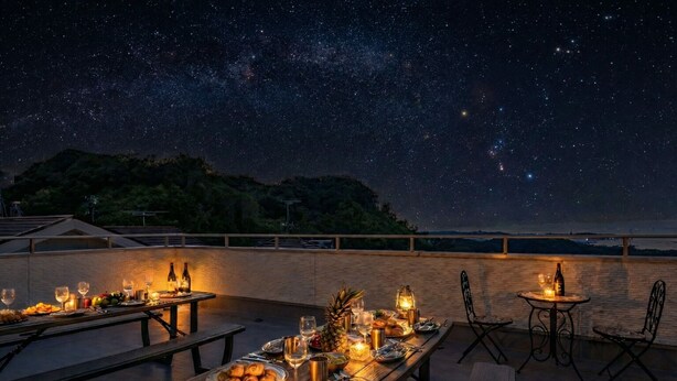 An outdoor dining area with tables set for a meal, under a night sky filled with stars. - PEACE OF REST  SHIRAHAMA (Shirahama)