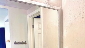 A bathroom with a sink, mirror, and towel rack. - Direct Beach access! 2 queen beds private balcony, plus an ocean to the left. (Cape May)