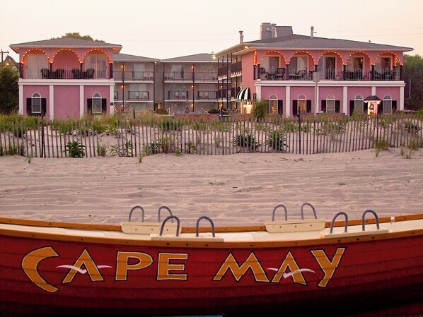 Un hotel frente a la playa con varios balcones y una playa de arena.