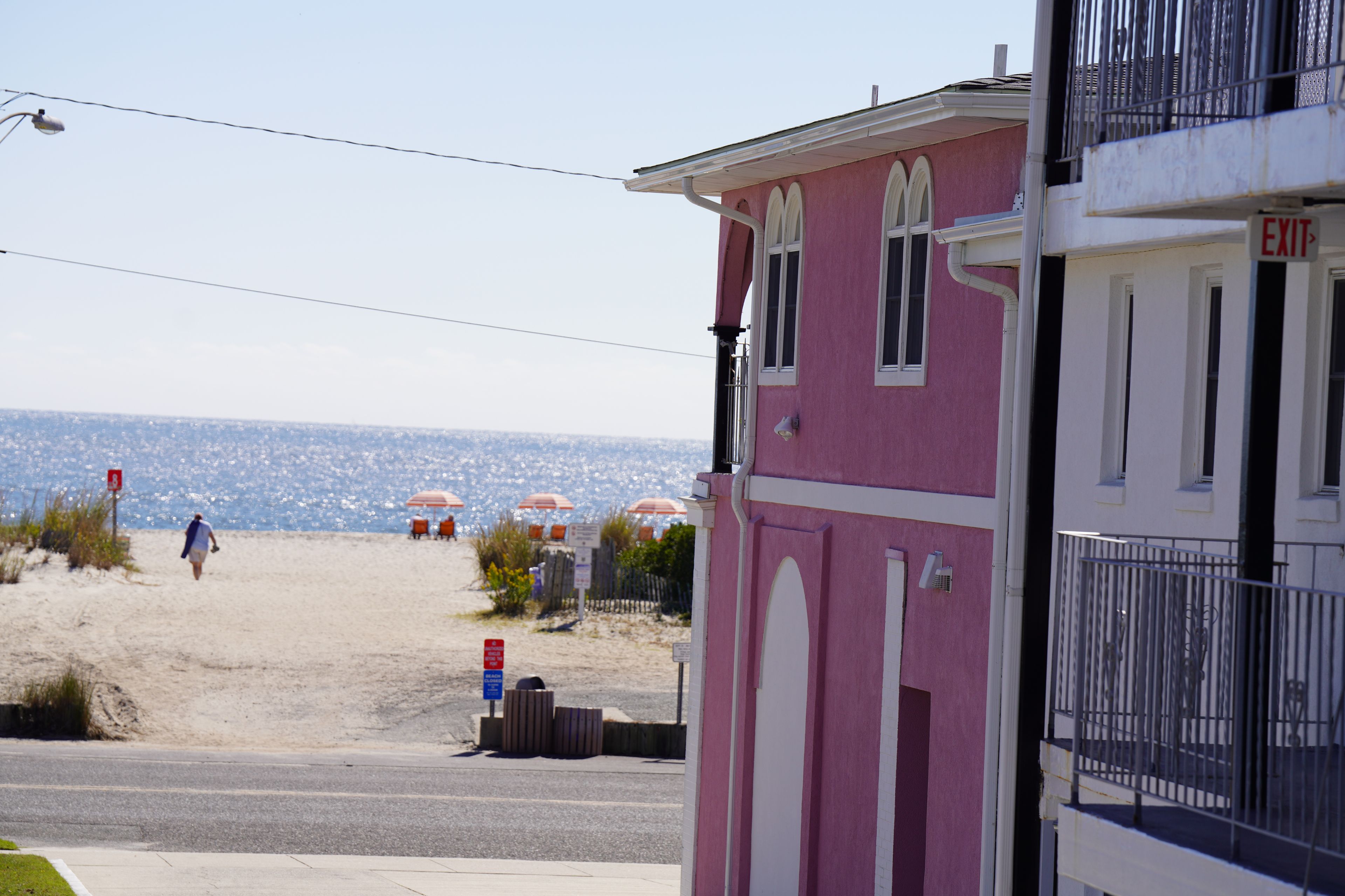 A pink building with a white door and an 'EXIT' sign.