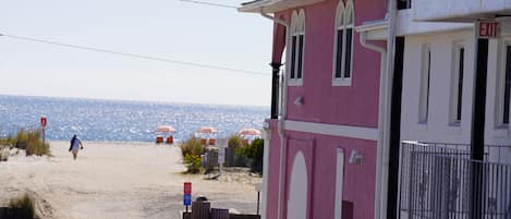 A pink building with a white door and an 'EXIT' sign.
