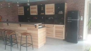 A kitchen with a central island, bar stools, and a refrigerator.