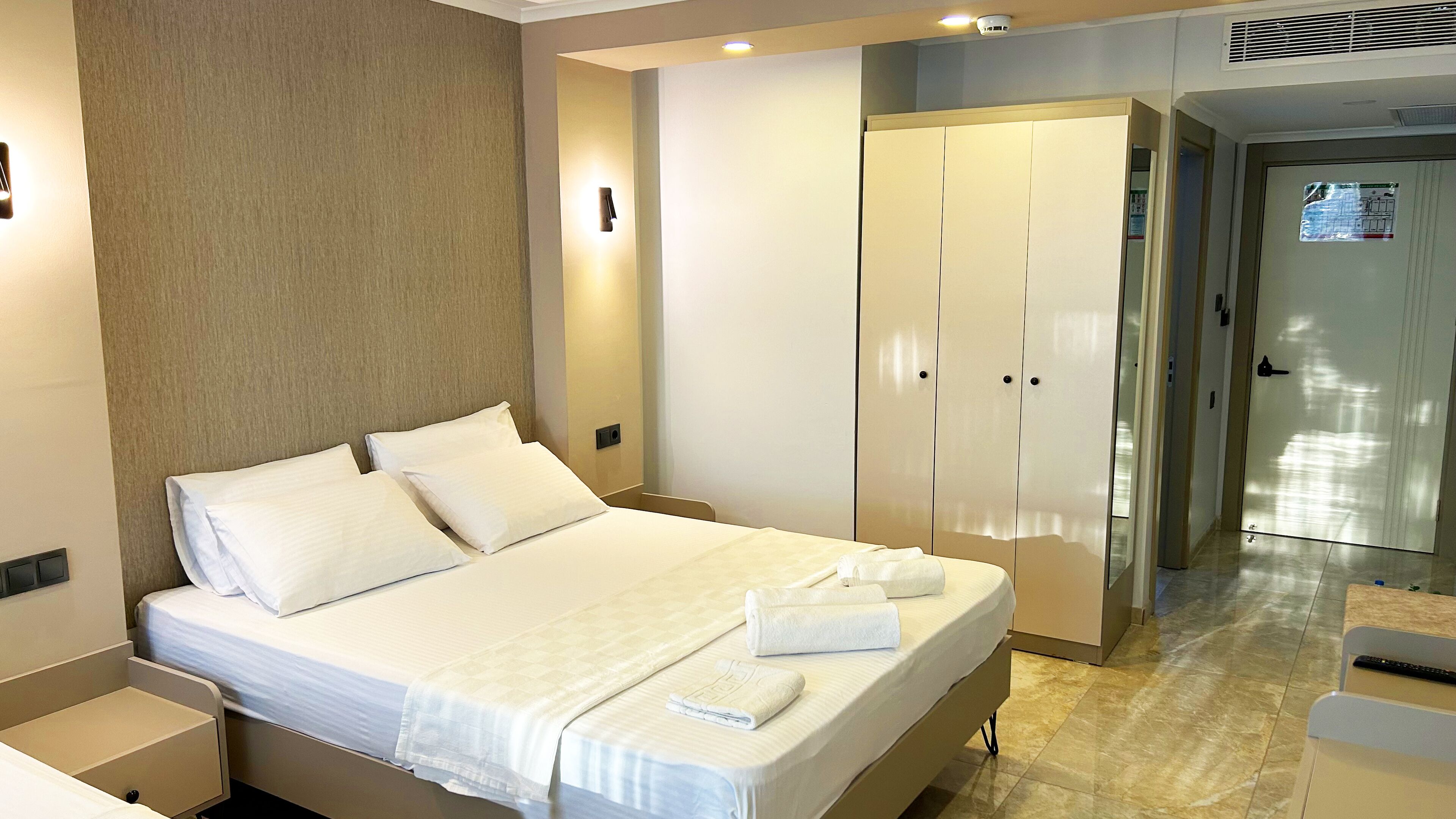 Una habitación de hotel con cama, armario y baño.