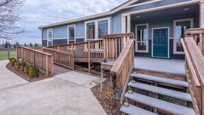 A modern two-story building with a wooden deck and a blue door. - Vineyard Vista Retreat | Close to Wineries, Lakes, & More! Sleeps 6, Hot Tub (Clements)