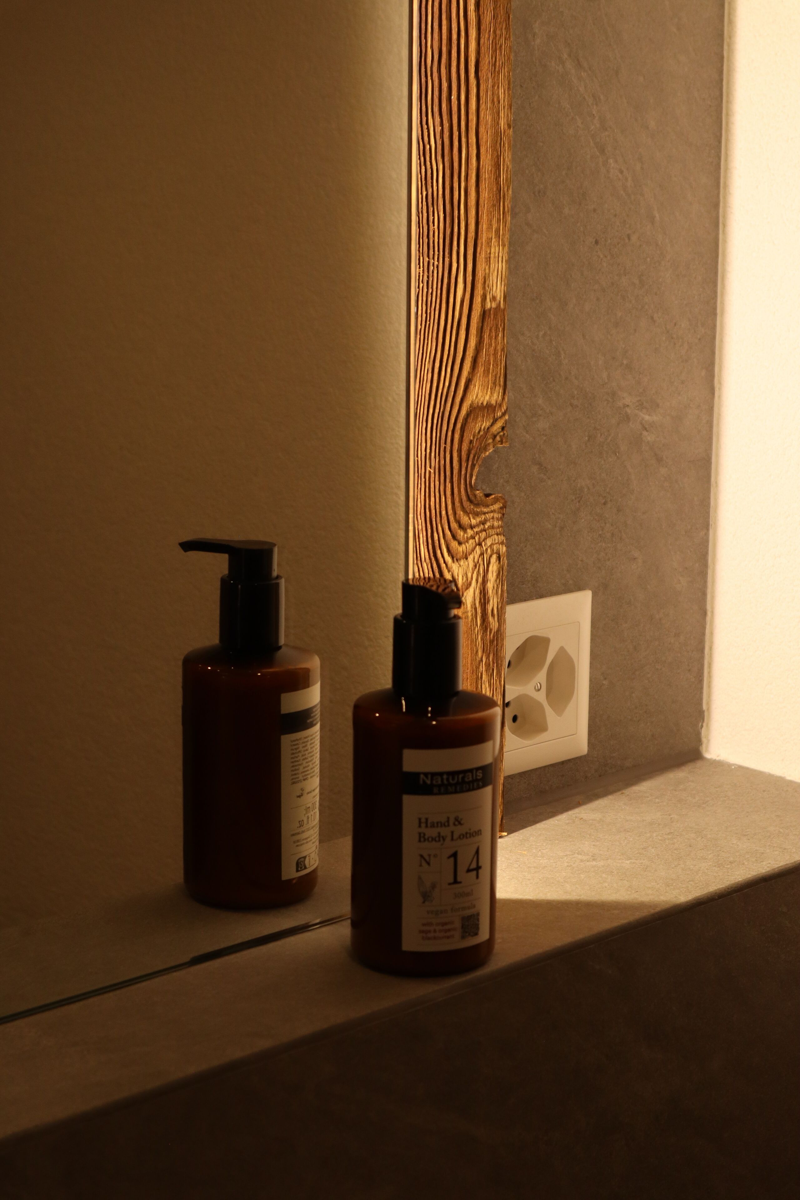 Two bottles of hand and body lotion on a shelf.