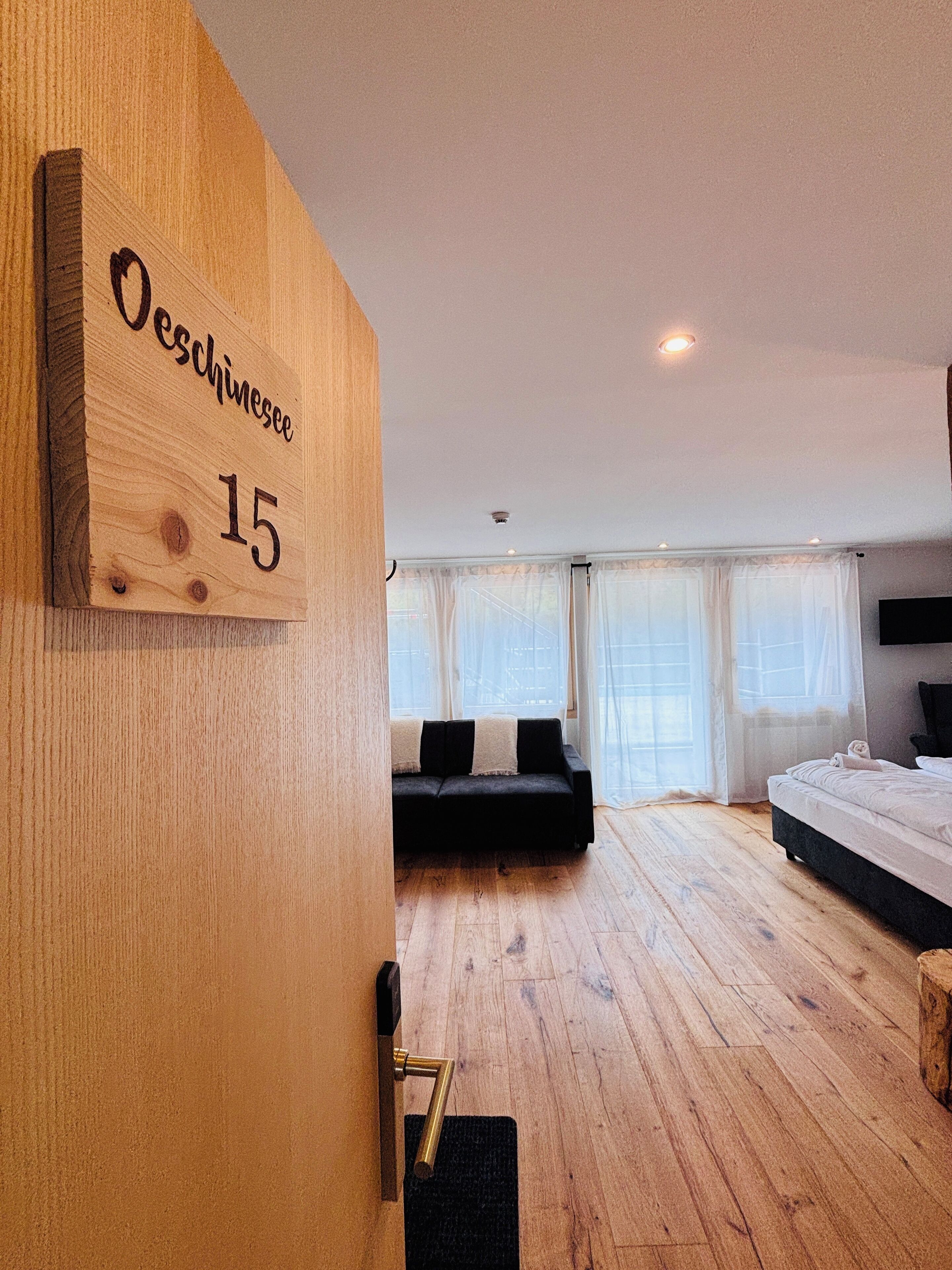 Een moderne slaapkamer met een houten wandbordje met de tekst 'Oeslingsee 15'.