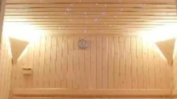 A wooden sauna with benches and a central heating element.