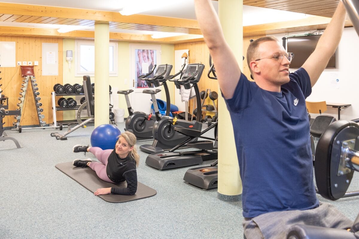 A gym with exercise equipment, including treadmills, dumbbells, and exercise balls.