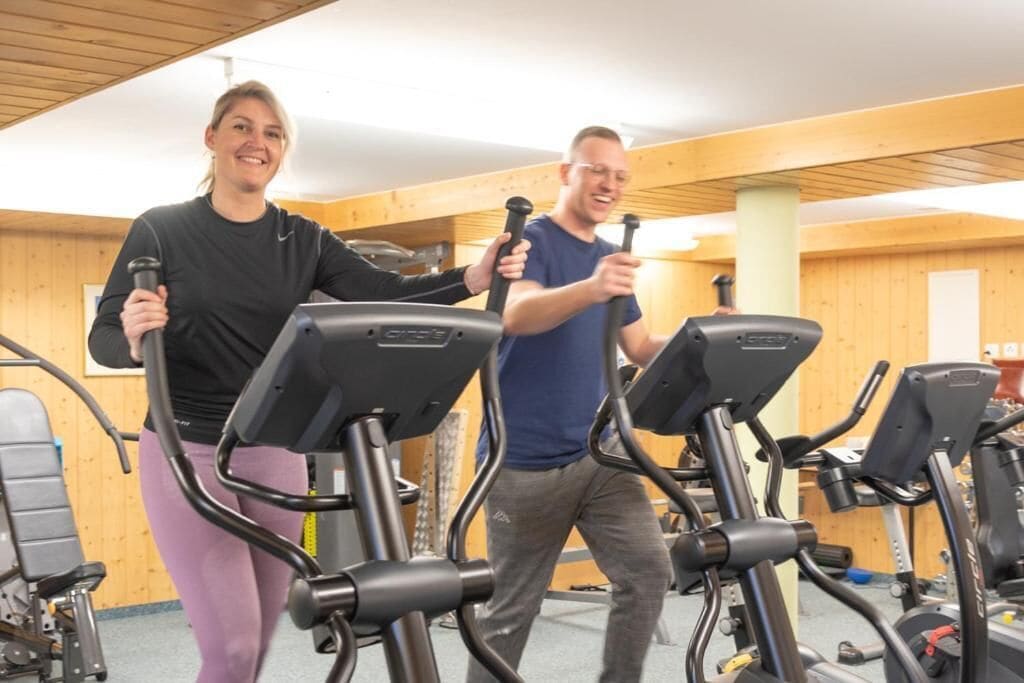 A gym with stationary bikes and a person using a bike.