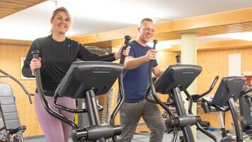 A gym with stationary bikes and a person using a bike.