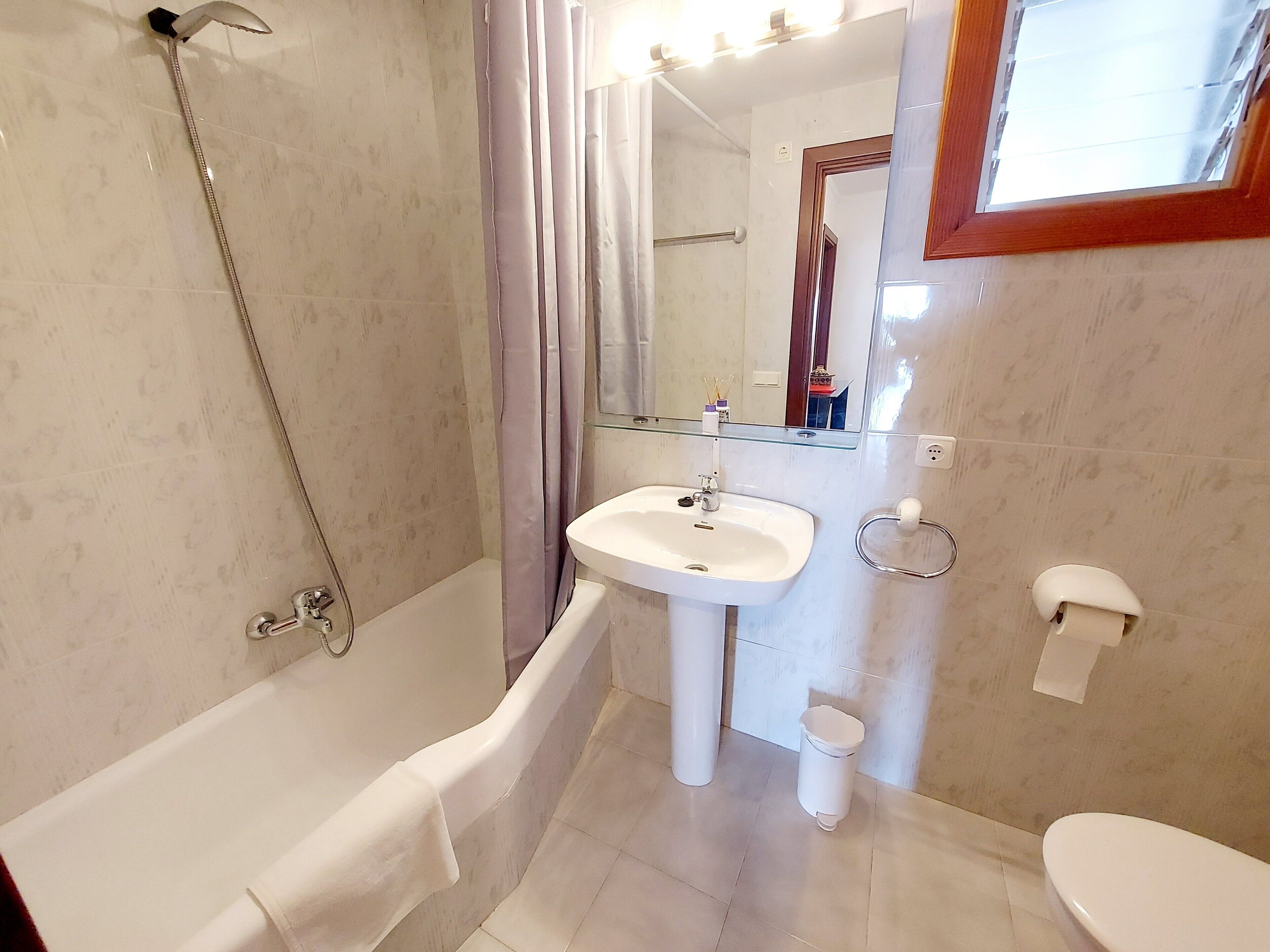 A bathroom with a bathtub, a sink, a toilet, and a shower.