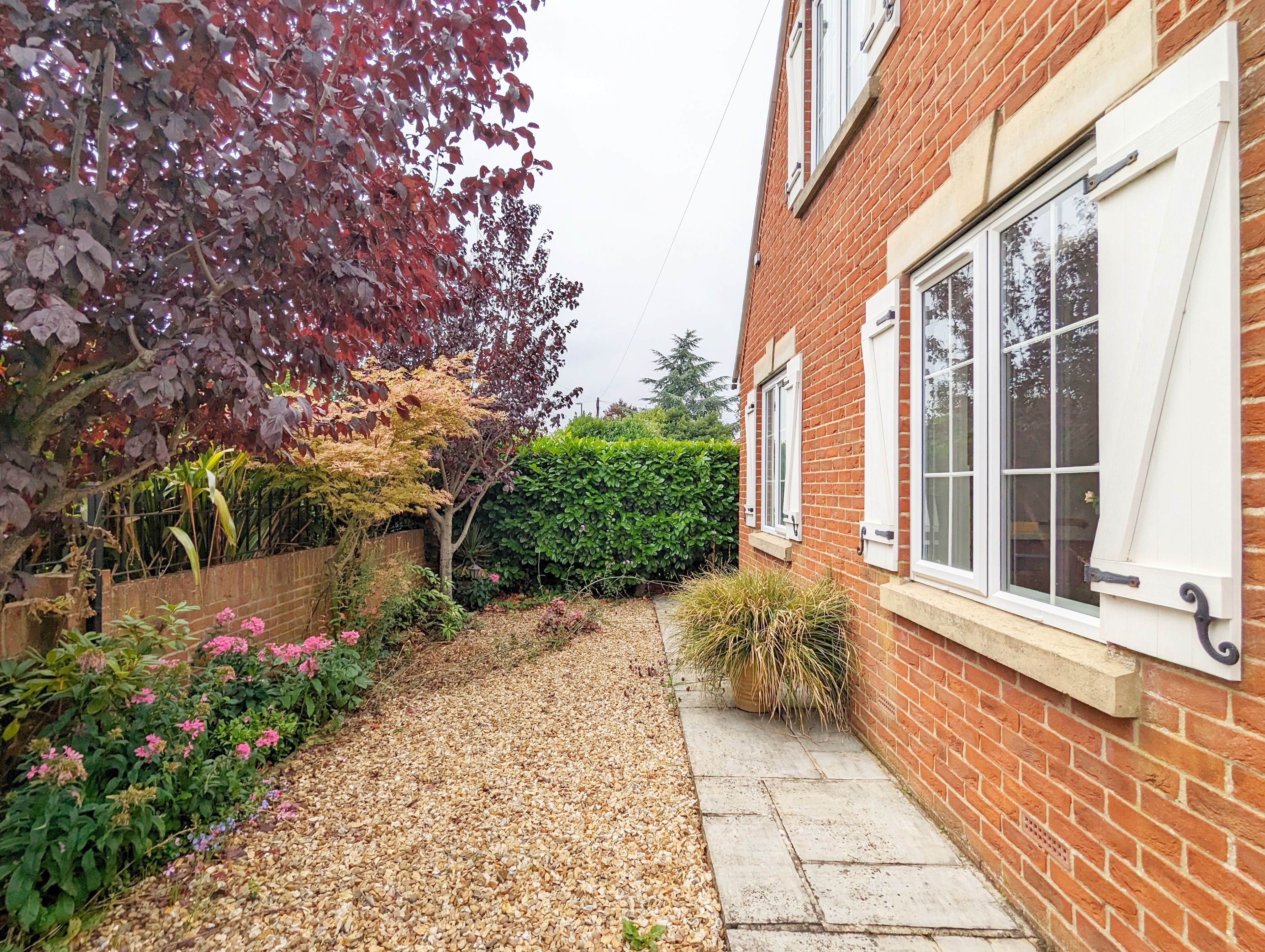 A brick house with a gravel pathway leading to a white door.