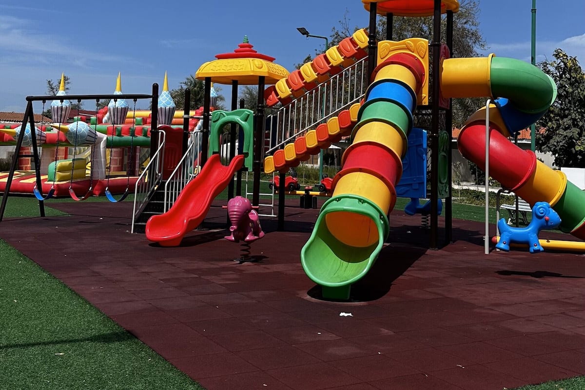 Ein Spielplatz mit mehreren Rutschen und Klettergerüsten.
