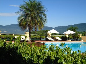 Una piscina cubierta, una piscina al aire libre, tumbonas