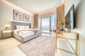 Une chambre d’hôtel moderne dotée d’un grand lit, d’une télévision, d’un bureau et d’un balcon avec vue.