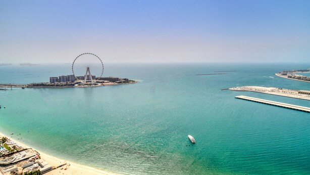 A coastal area with a large Ferris wheel, a marina, and a beach. - Picturesque 3BR with Assistant Room at The One JBR by Deluxe Holiday Homes (Dubai)