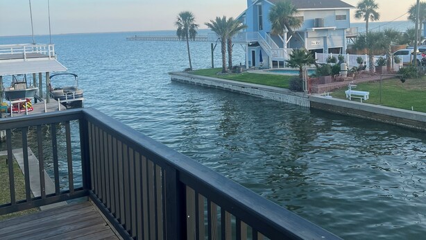Une propriété située au bord de l’eau, dotée d’un quai, d’une maison avec balcon et offrant une vue sur l’eau.