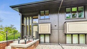 A modern building with a flat roof, large windows, and a brick foundation. - Glass Vista: Modern 2BR Condo, Lake Views (Lake Geneva)