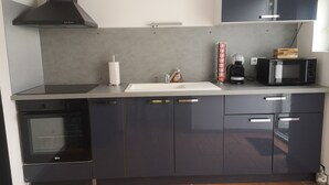 Een moderne keuken met een inbouwoven, een magnetron en een koffieapparaat.