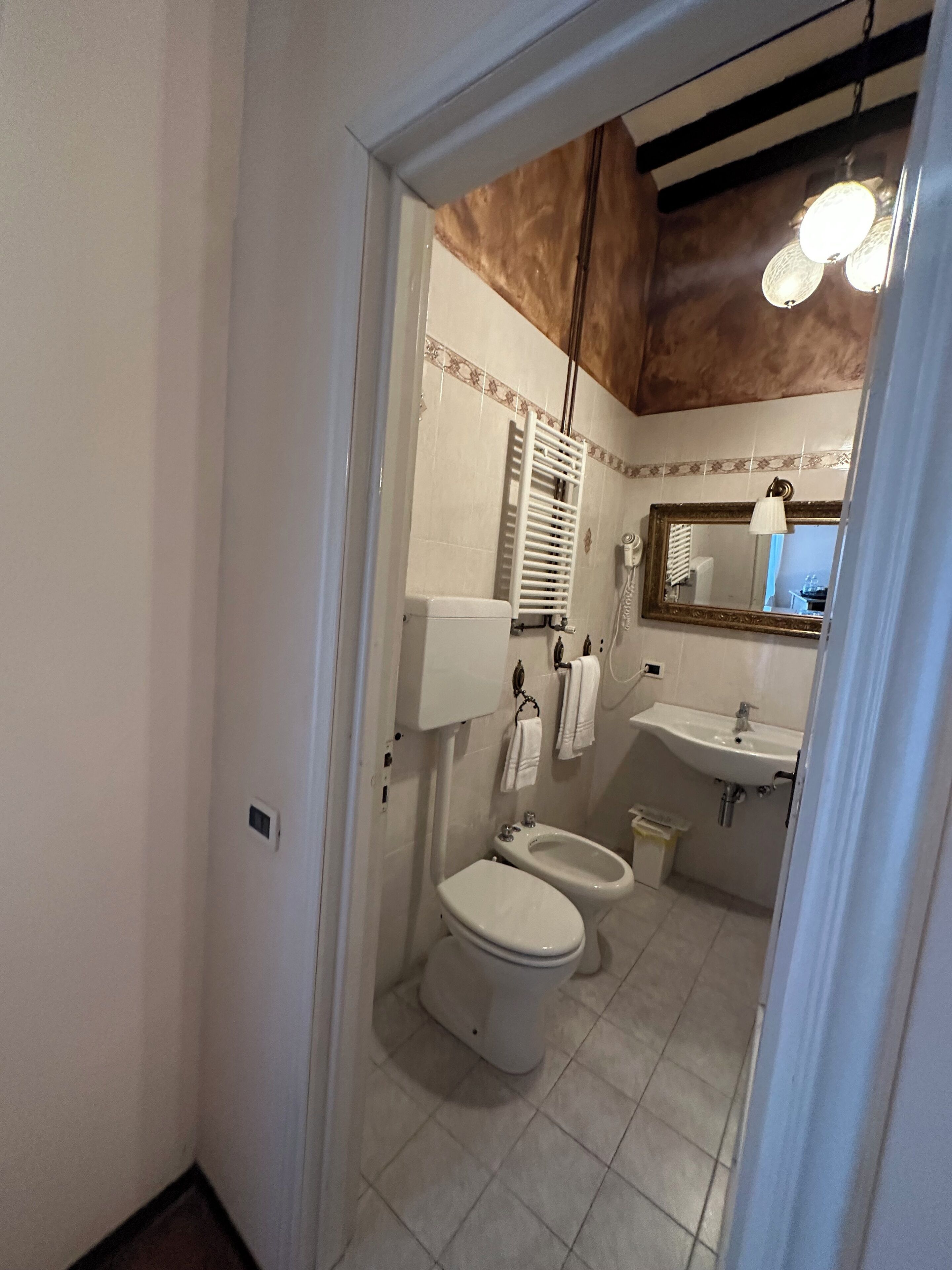 Un bagno con servizi igienici, bidet, lavandino e specchio.
