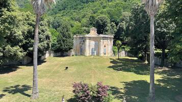 Un edificio histórico con un patio central, rodeado de abundante vegetación y palmeras.