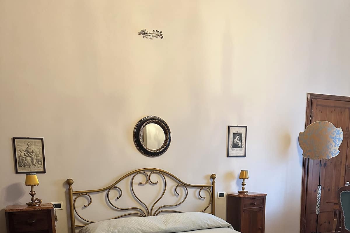 A bedroom with a bed, a nightstand, a dresser, a mirror, and a chair.
