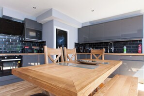 Enjoy cooking in this well-lit kitchen with a microwave, oven, and dining table.