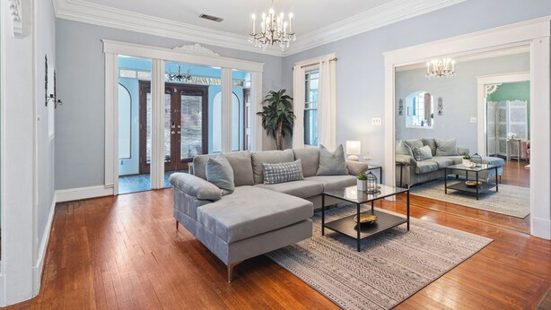 A spacious living room with a large sectional sofa, a glass coffee table, and a chandelier. - Charming Vintage 1BR, 1BA Apartment in Midtown @Piedmont Park. (Atlanta)