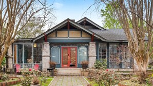 A traditional house with a front porch, stone pillars, and a red door. - Charming Vintage 1BR, 1BA Apartment in Midtown @Piedmont Park. (Atlanta)