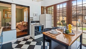 A kitchen with a checkered floor, a dining table with a tray of lemons, and a sign that says "EAT" on the wall. - Charming Vintage 1BR, 1BA Apartment in Midtown @Piedmont Park. (Atlanta)