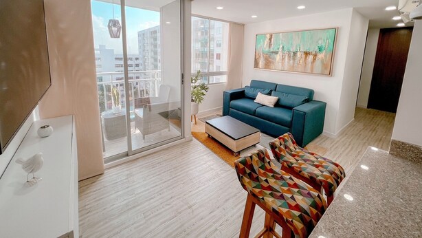 A modern living room with a sofa, a coffee table, and a colorful bench.