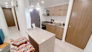 A modern kitchen with a central island, wooden cabinets, and a built-in oven.