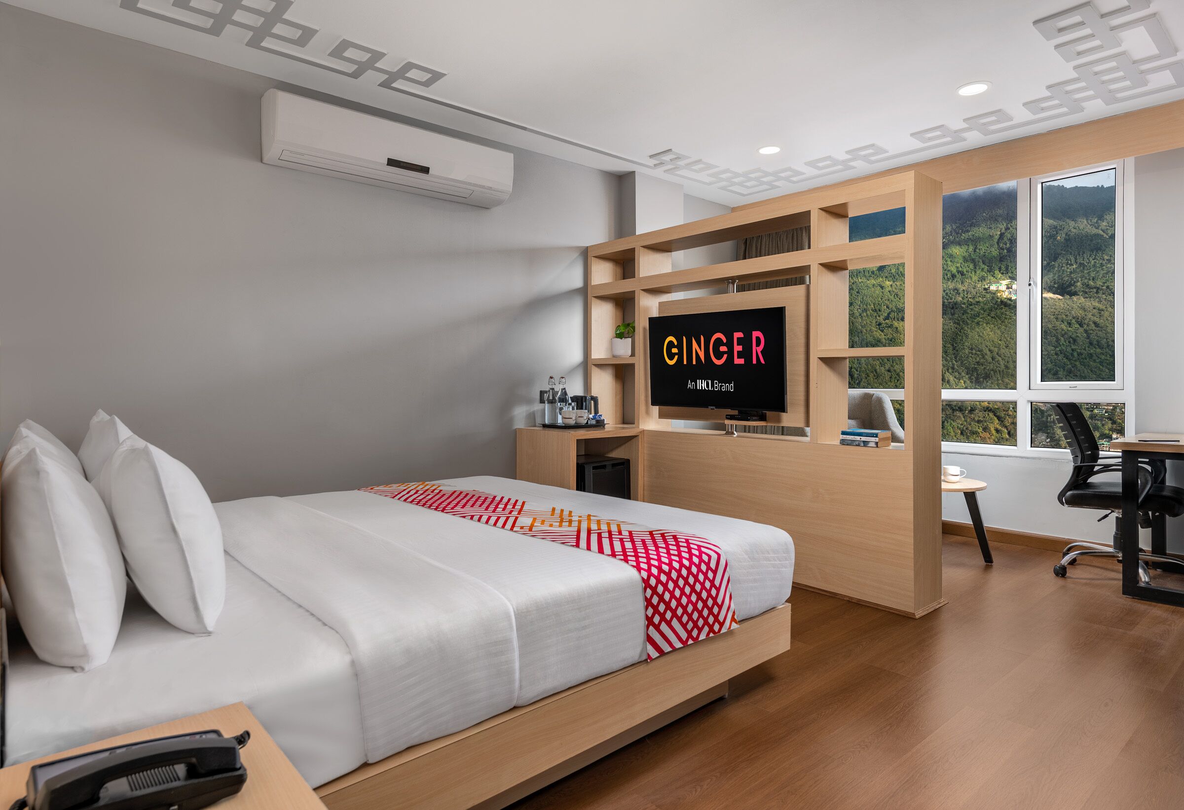 A modern hotel room with a bed, a desk, a chair, a TV, and a window with a view of the outdoors.
