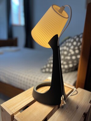 A modern lamp with a ribbed shade on a wooden nightstand in a bedroom. - Chez Marie (Albaret-Sainte-Marie)