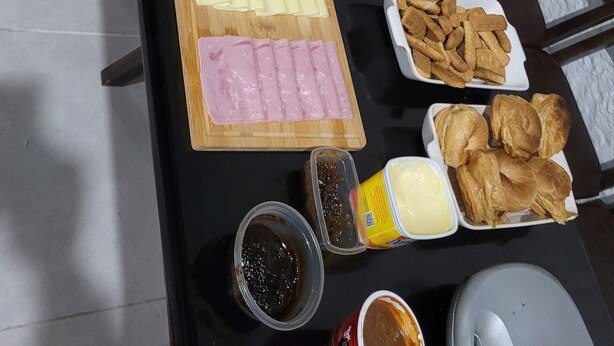 Una mesa de buffet con diversos alimentos, como pasteles, frutas y carnes.