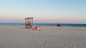 A beach with a lifeguard tower, sand, and the ocean. - Beautiful waterfront home- mins to beach, fishing /kayak right from the backyard (Yarmouth)