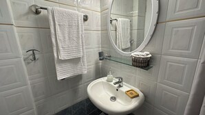 A bathroom with a white sink, a mirror, and two towels hanging on towel racks. - Zen Studio 2 min from the beach with a spacious veranda, free WiFi, and A/C. (Rethymno)