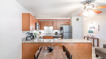 A modern kitchen with wooden cabinets, granite countertops, and a central island with seating.