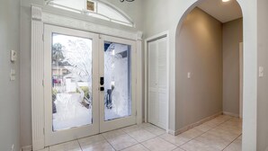 A hallway with a double door featuring frosted glass panels, a tiled floor, and a recessed ceiling light. - Delray Castle-Minutes to the beach and Atlantic Ave (Delray Beach)