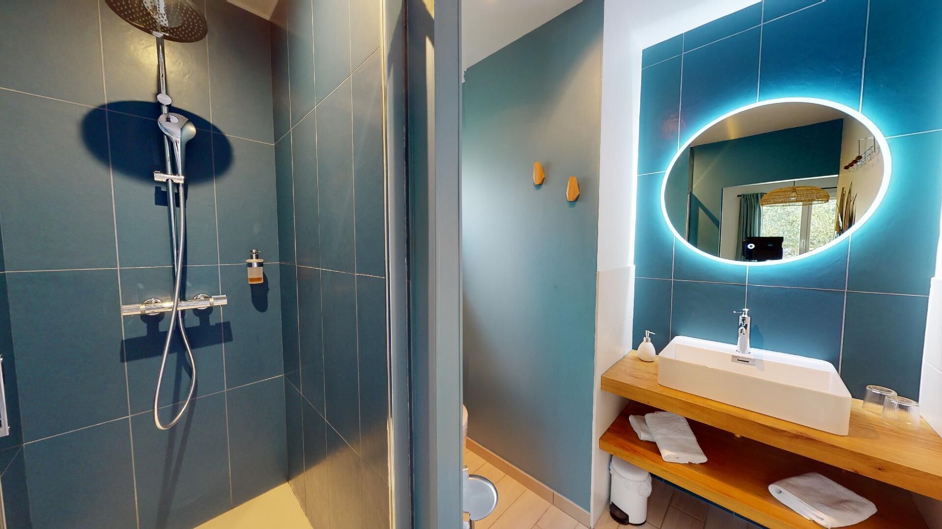 Une salle de bain moderne équipée d’une douche, d’un lavabo et d’un miroir.