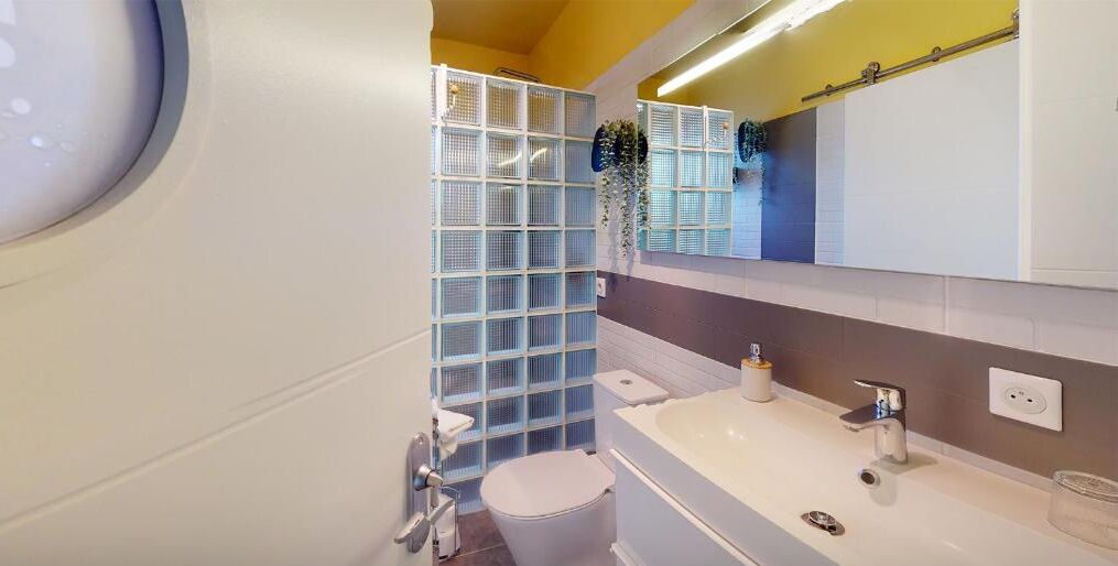 Ein modernes Badezimmer mit Toilette, Waschbecken und Duschbereich.