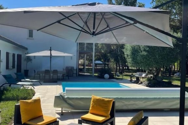 Piscina a l'aire lliure de temporada, para-sols i gandules