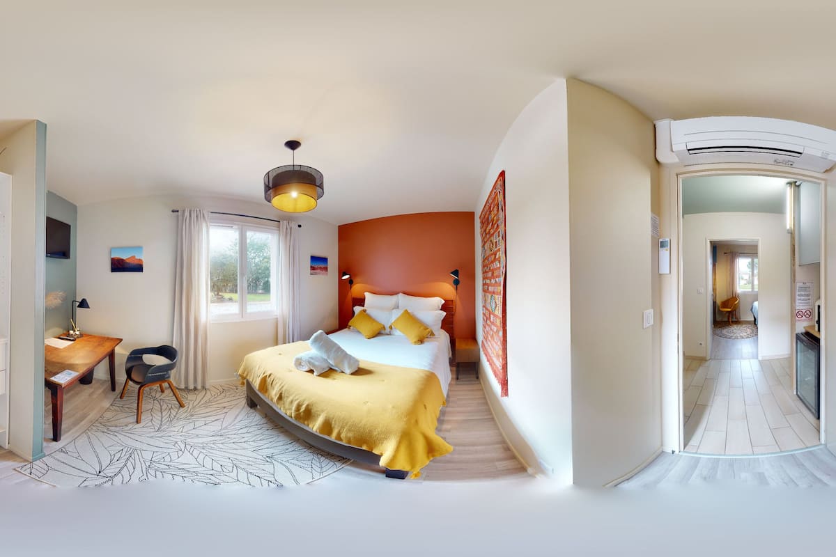 A compact bedroom with a bed, bedside table, chair, and wardrobe.