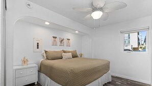 A bedroom with a bed, a nightstand, a ceiling fan, and a window. - Condo on the Bay! Prime Location!  (San Diego)
