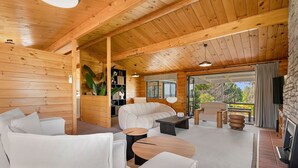Un intérieur chaleureux avec des éléments en bois, comprenant un canapé, une table basse et une cheminée.