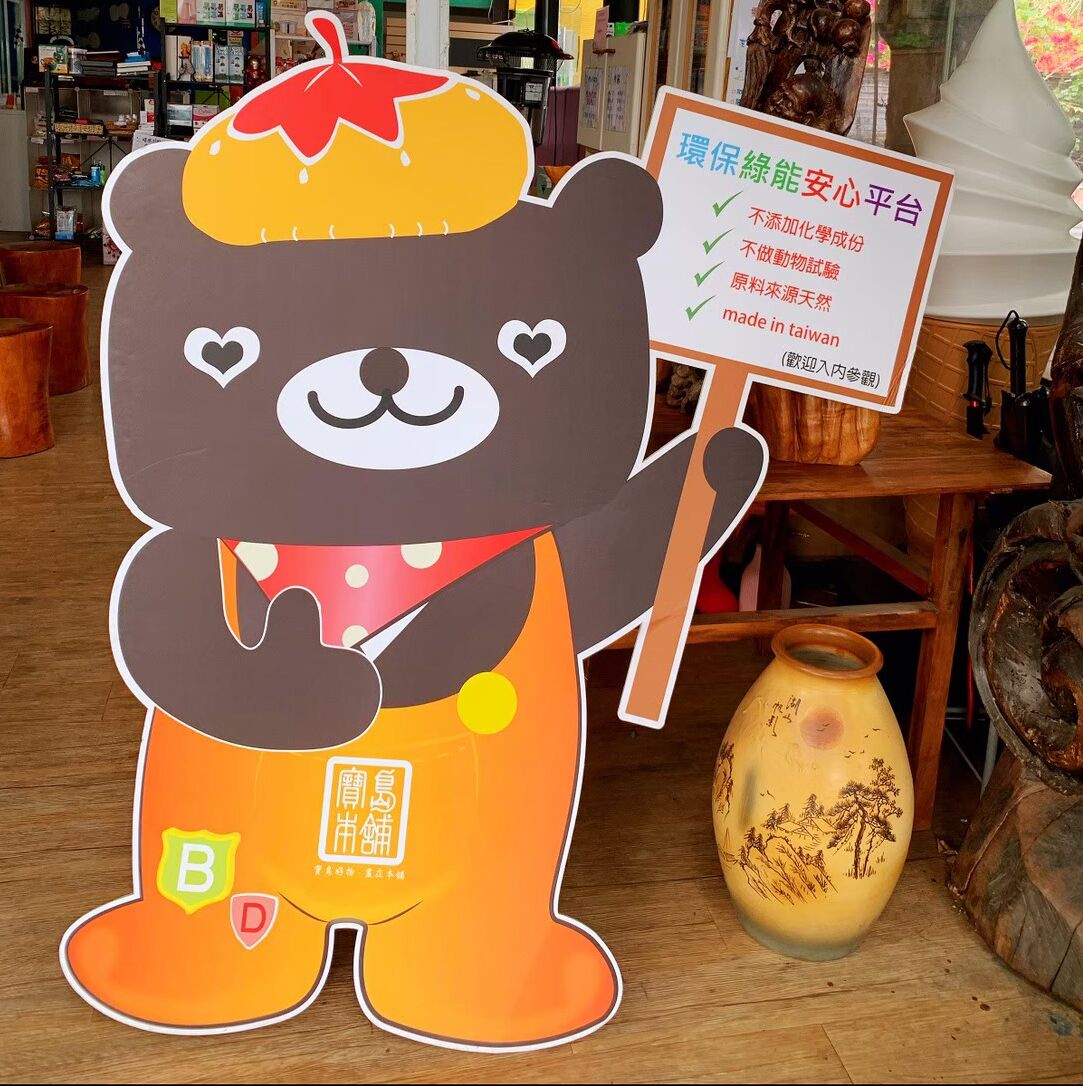 Um mascote de urso segurando um letreiro em uma loja.